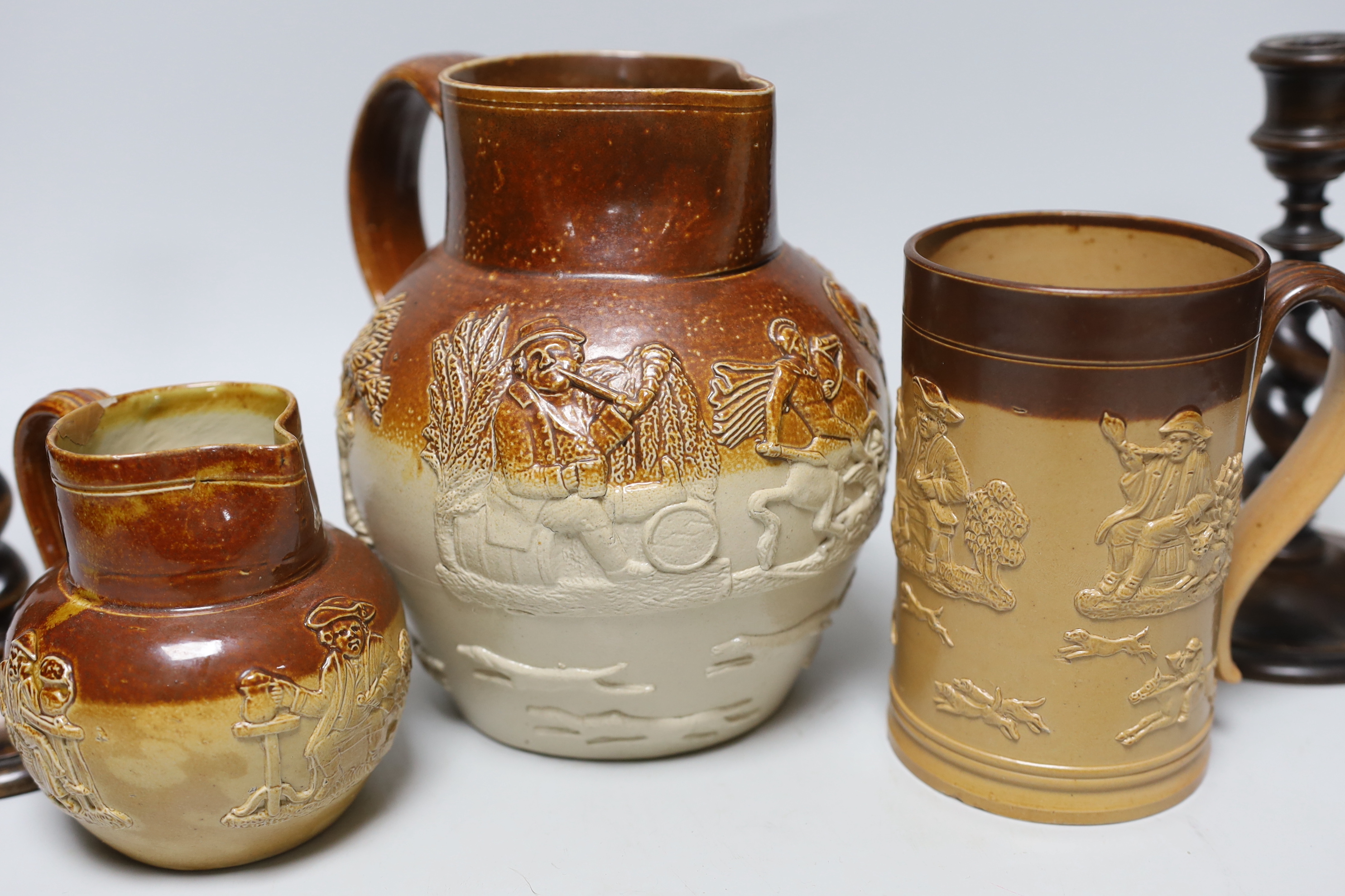 A group of three salt-glazed stoneware vessels and a pair of walnut barley-twist candlesticks, the largest 19cm high